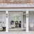 View into a sophisticated pool house with neutral furnishings and navy accents. Interior design by Jamie Merida Interiors.