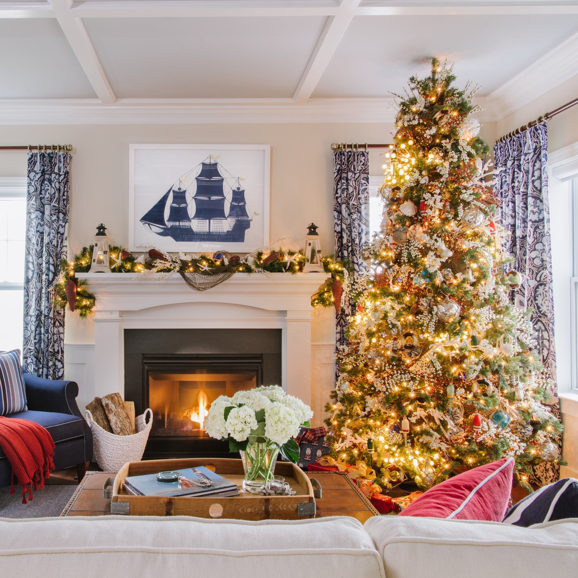 Warm living room with fireplace and brightly lit Christmas tree. Interior design by Jamie Merida.
