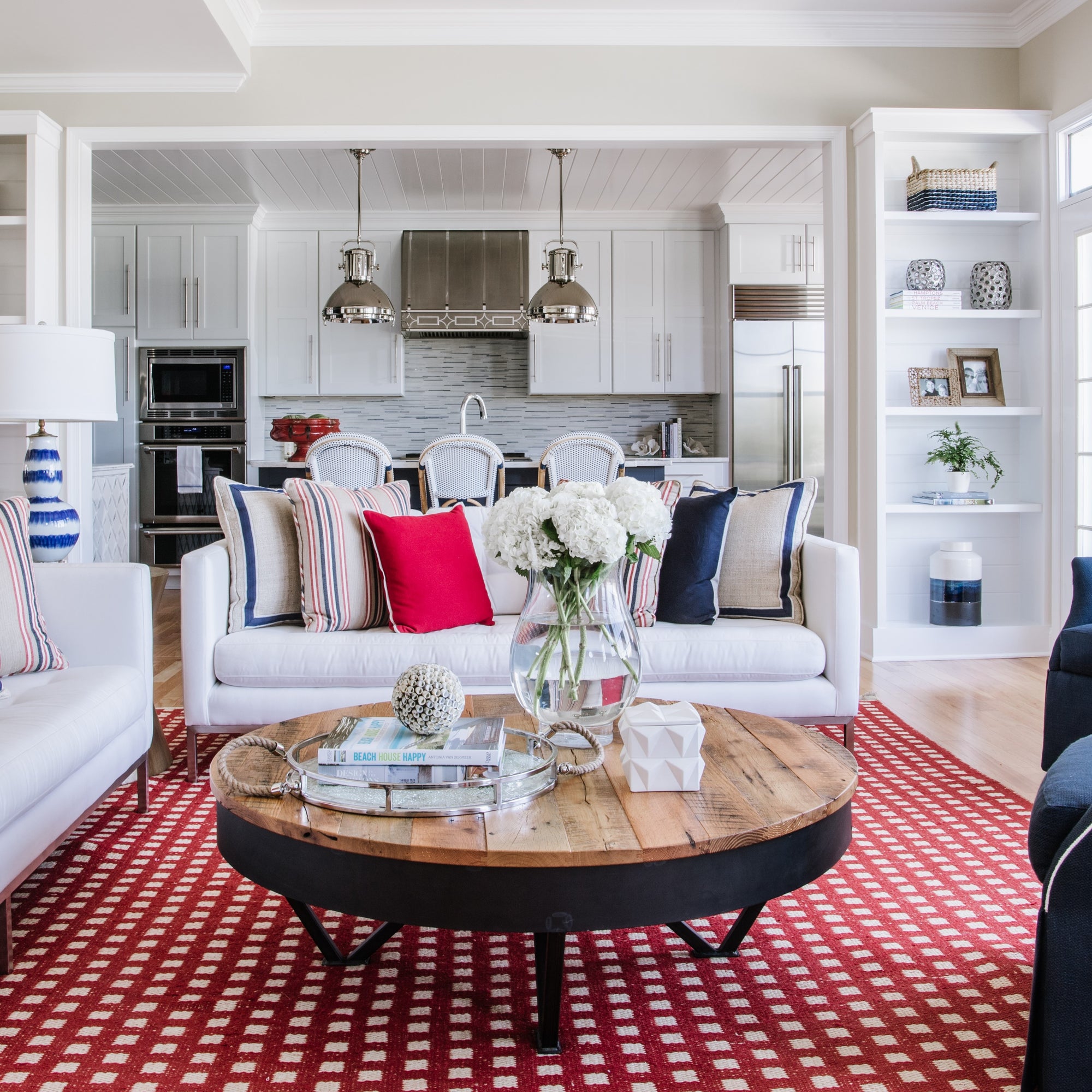 Eastern Shore modern luxury by Jamie Merida Interiors - shows red, white, and blue sitting room with nautical style; kitchen in background