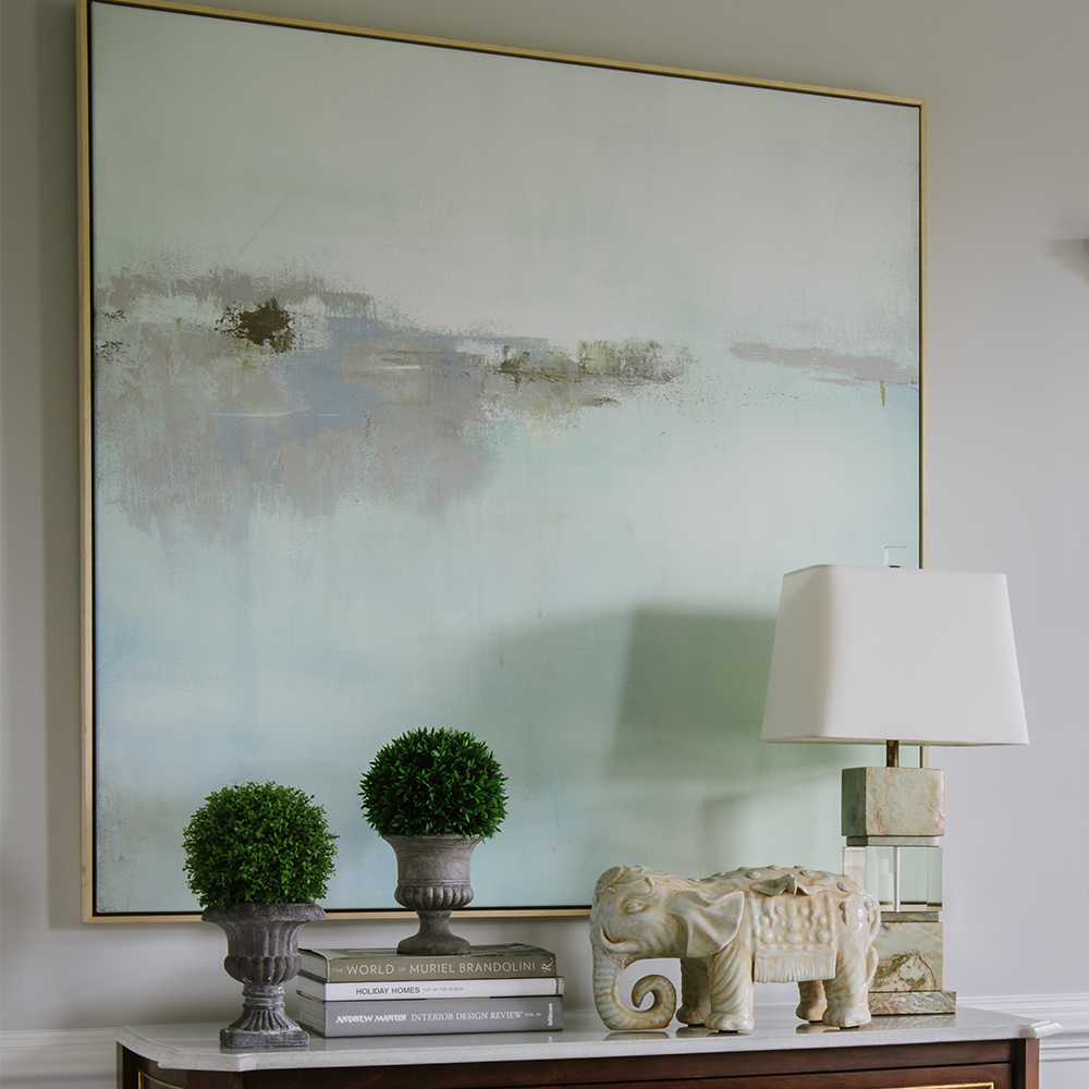 Art & wall decor at Bountiful Home - abstract painting in soft colors above an entry table with a lamp and home accessories